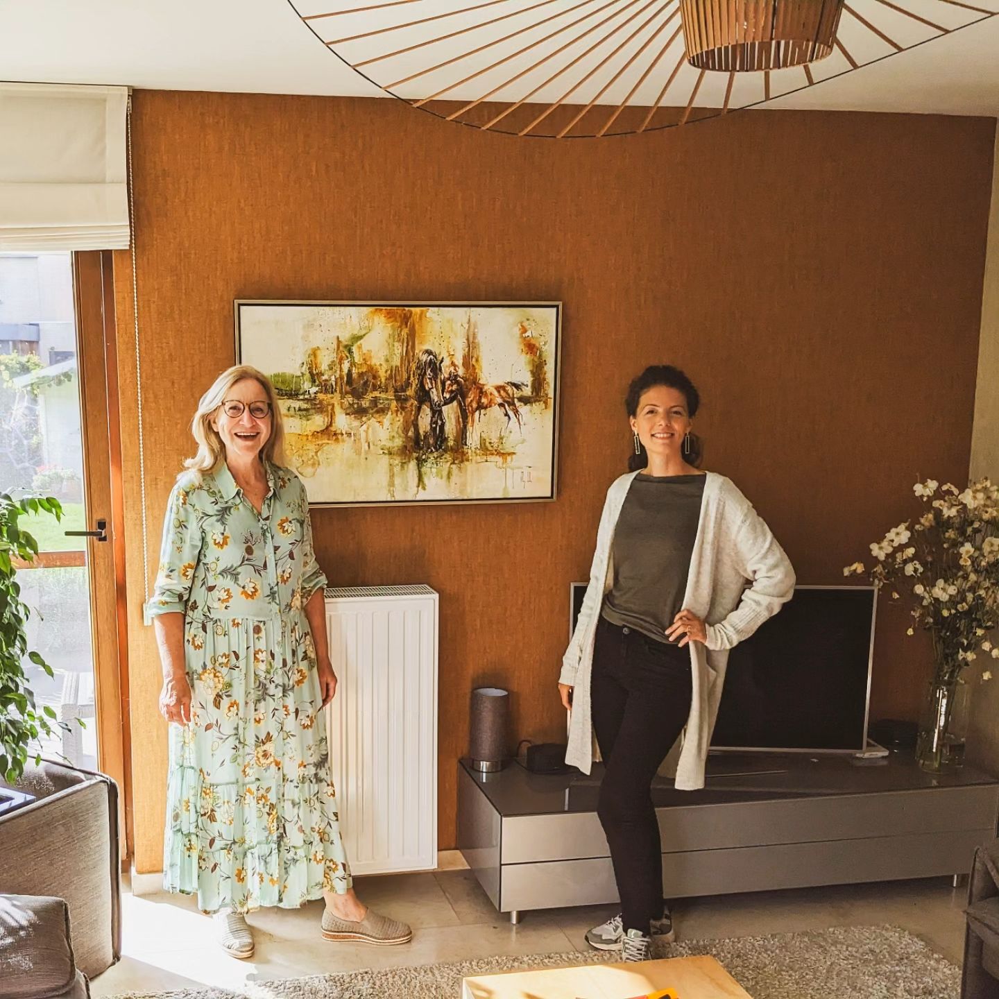 Marjo Lebbe with a collector beside an equine painting in her home