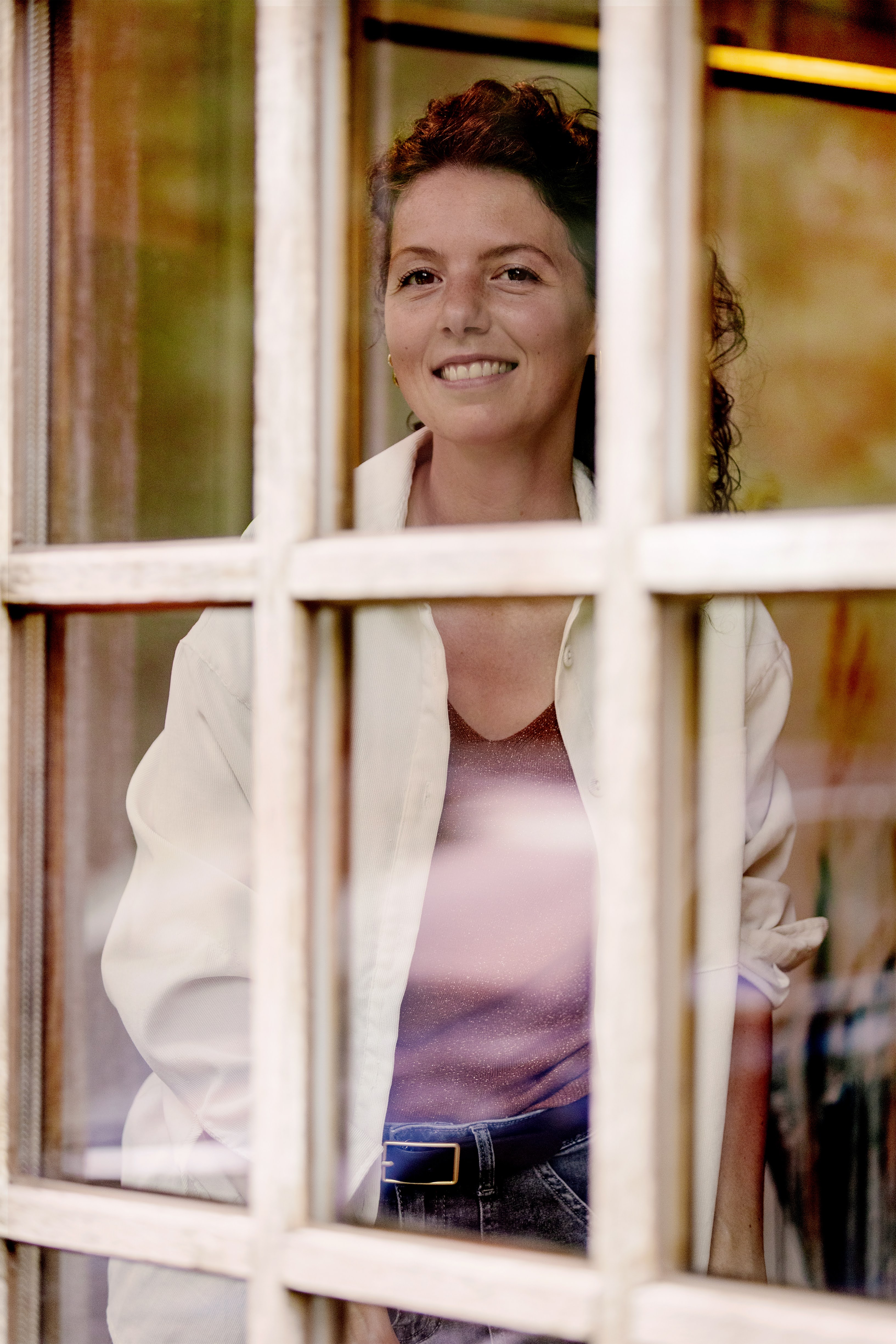 Marjo smiling in her sunlit studio