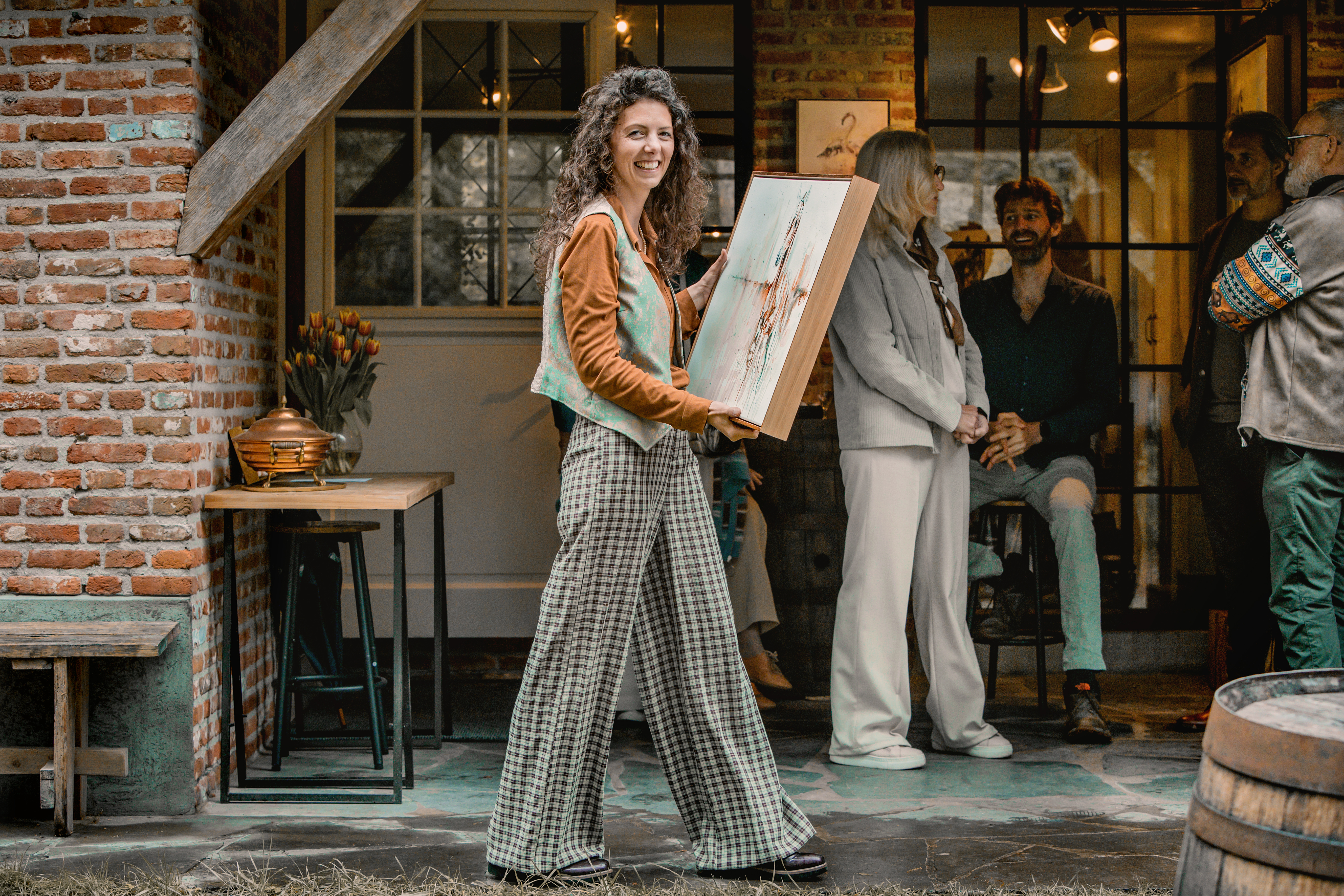 Marjo carrying a painting among friends and collectors