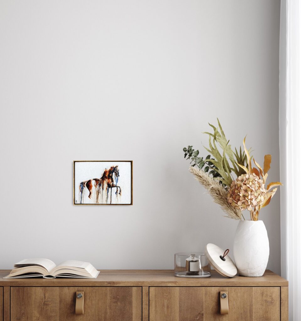 A small framed horse painting above a cabinet, shown for scale
