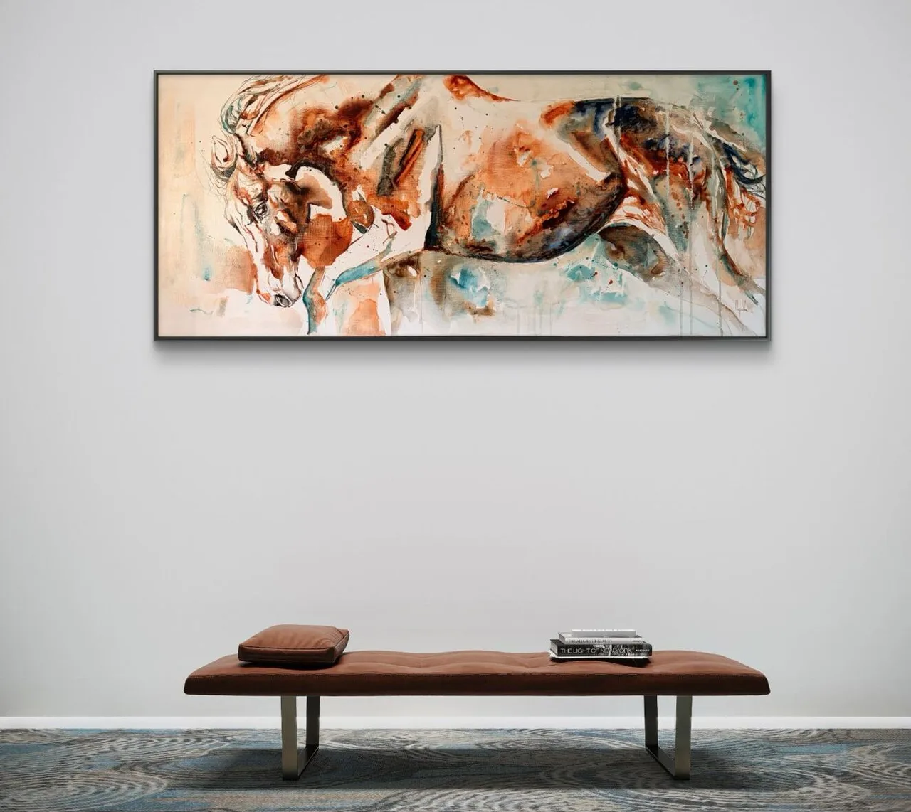 Bronze aan de muur boven een leren bank in een rustig, minimalistisch interieur