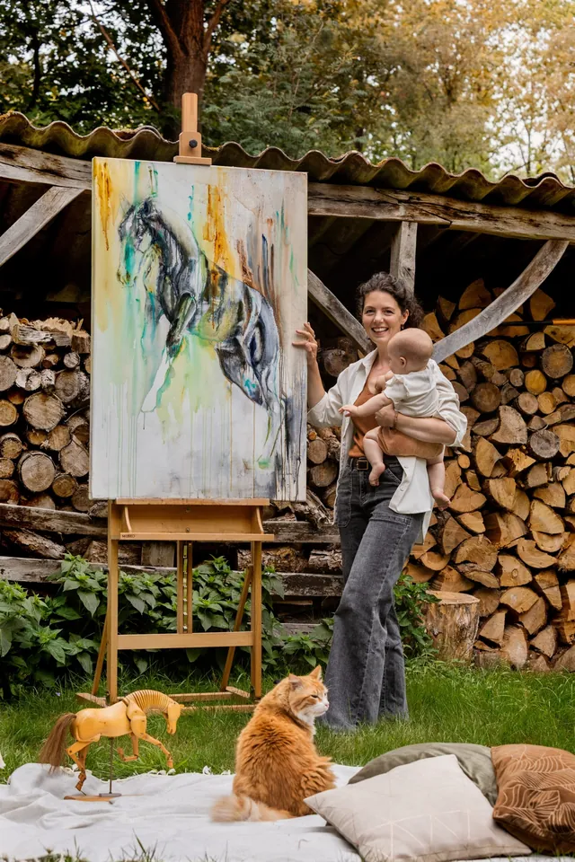 Marjo met een van haar katten naast het schilderij