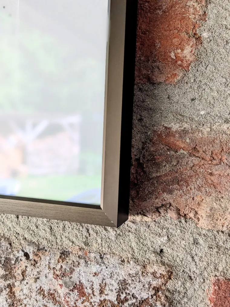 The brushed aluminium frame and glass of Equus et Avis, the studio window reflected in it