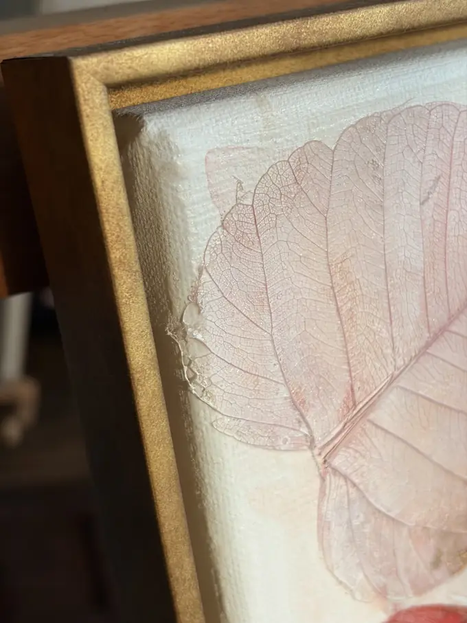 The corner of the wooden floating frame, the canvas edge sitting free inside it