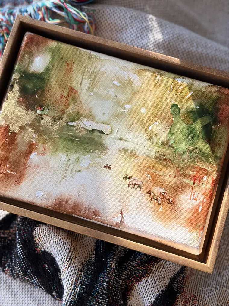 Een Small things aquarel op een geweven deken in daglicht, van bovenaf gezien